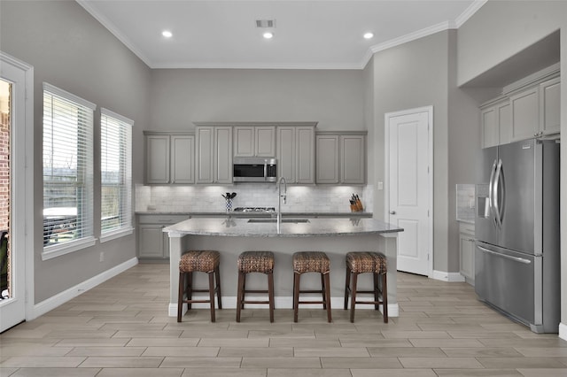 15534 Ponderosa Bend Dr, Cypress, TX 77429 - kitchen featuring stainless steel appliances, backsplash, visible vents, a sink, and gray cabinetry