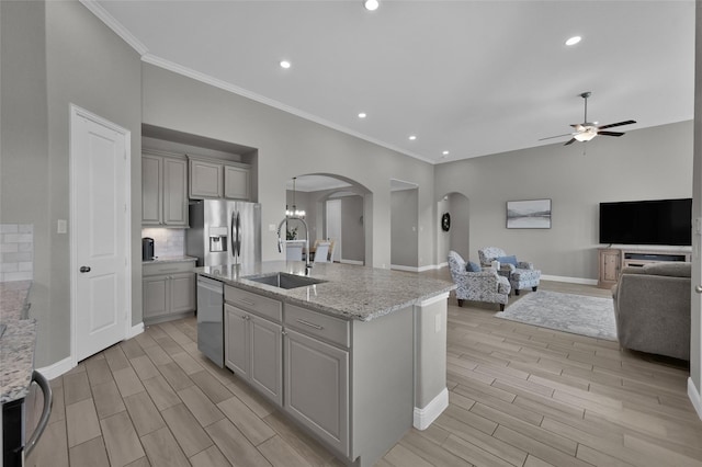 15534 Ponderosa Bend Dr, Cypress, TX 77429 - kitchen featuring gray cabinetry, a sink, arched walkways, and appliances with stainless steel finishes