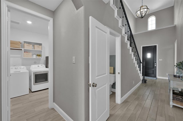 15534 Ponderosa Bend Dr, Cypress, TX 77429 - entrance foyer featuring light wood-style flooring, washer and clothes dryer, baseboards, an inviting chandelier, and stairs