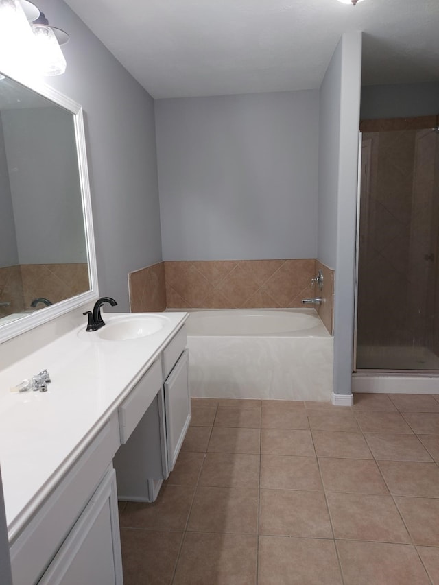 bathroom featuring a shower stall, a bath, tile patterned floors, and vanity