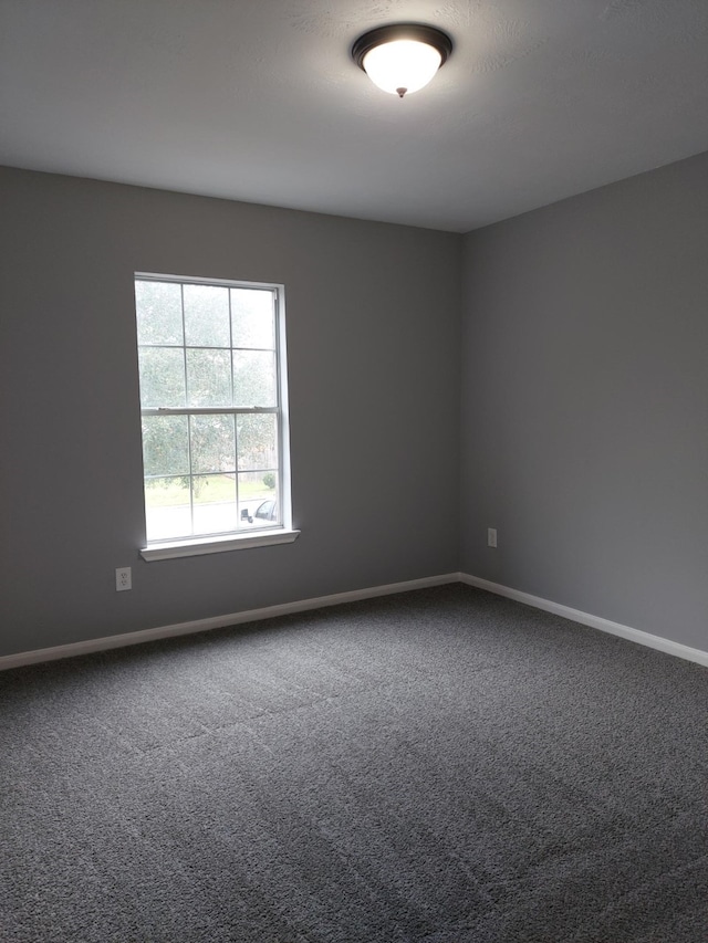 empty room featuring carpet floors and baseboards