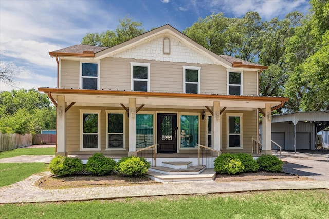 view of front of house featuring an outbuilding, a porch, and fence