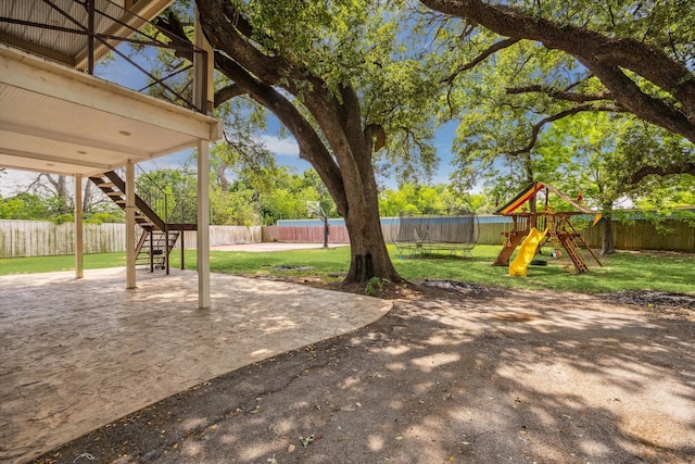 view of yard featuring stairway, a patio area, a fenced backyard, and a playground