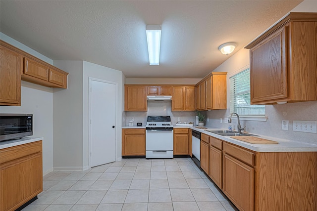 215 Pebble Canyon Ln, Dickinson, TX 77539 - kitchen featuring white appliances, a sink, under cabinet range hood, light countertops, and light tile patterned flooring