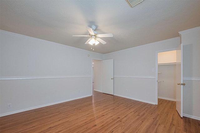 215 Pebble Canyon Ln, Dickinson, TX 77539 - unfurnished bedroom with light wood-type flooring, a walk in closet, baseboards, a closet, and a ceiling fan
