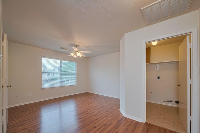 215 Pebble Canyon Ln, Dickinson, TX 77539 - unfurnished bedroom with wood finished floors, baseboards, a ceiling fan, and a closet