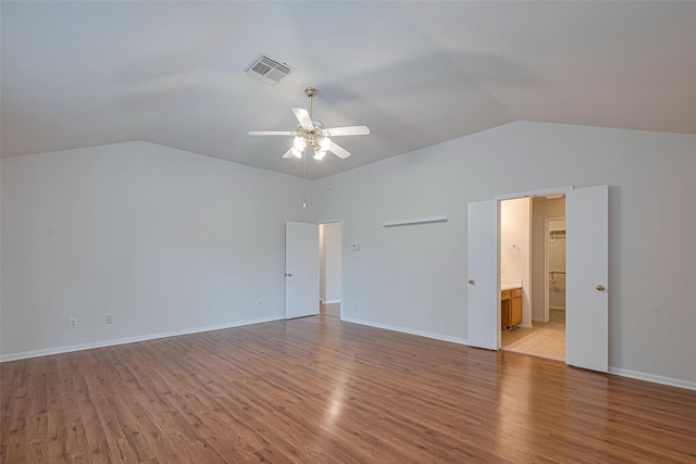 215 Pebble Canyon Ln, Dickinson, TX 77539 - unfurnished bedroom featuring vaulted ceiling, light wood-type flooring, connected bathroom, a ceiling fan, and baseboards