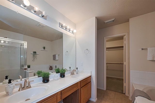 215 Pebble Canyon Ln, Dickinson, TX 77539 - full bath with tile patterned floors, double vanity, a garden tub, a stall shower, and a spacious closet