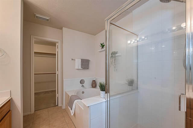 215 Pebble Canyon Ln, Dickinson, TX 77539 - full bath featuring a shower stall, tile patterned floors, vanity, a garden tub, and a spacious closet