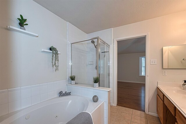 215 Pebble Canyon Ln, Dickinson, TX 77539 - full bathroom with tile patterned floors, vanity, a whirlpool tub, a shower stall, and a textured ceiling