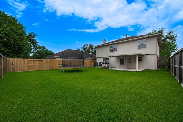 215 Pebble Canyon Ln, Dickinson, TX 77539 - back of house with a trampoline, a patio area, and a chimney
