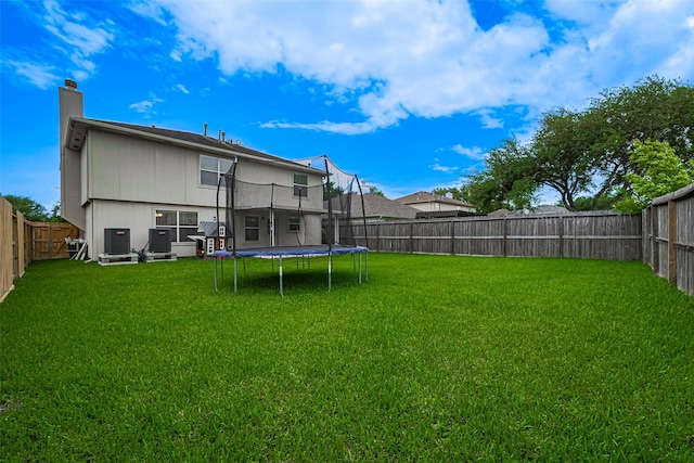 215 Pebble Canyon Ln, Dickinson, TX 77539 - back of house featuring a trampoline, a chimney, and central air condition unit
