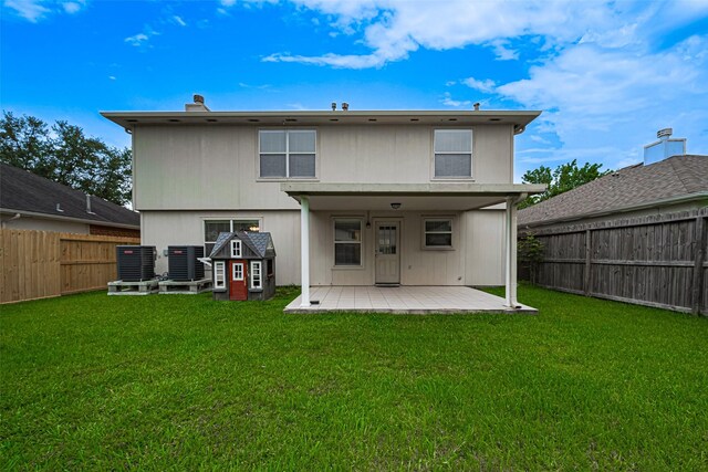 215 Pebble Canyon Ln, Dickinson, TX 77539 - rear view of house featuring a patio, central air condition unit, and a chimney