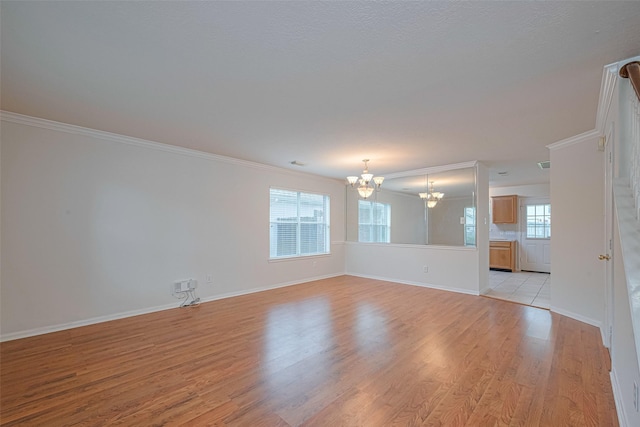 215 Pebble Canyon Ln, Dickinson, TX 77539 - spare room with a chandelier, crown molding, light wood finished floors, and baseboards
