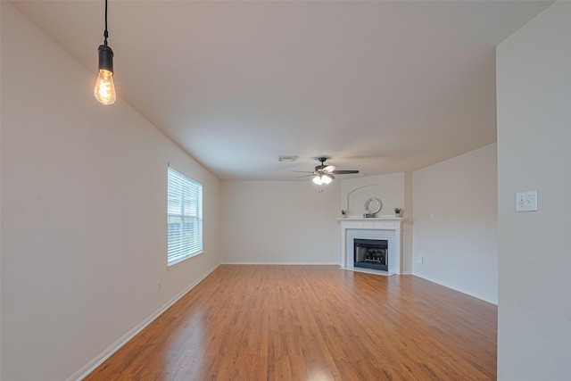 215 Pebble Canyon Ln, Dickinson, TX 77539 - unfurnished living room featuring ceiling fan, light wood-style flooring, a fireplace, and baseboards