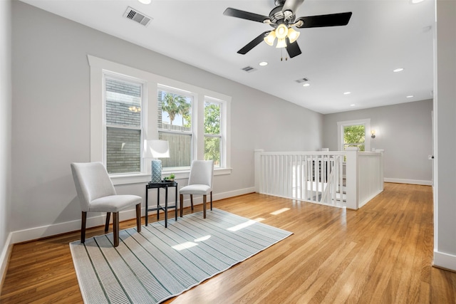 sitting room with baseboards, wood finished floors, and visible vents