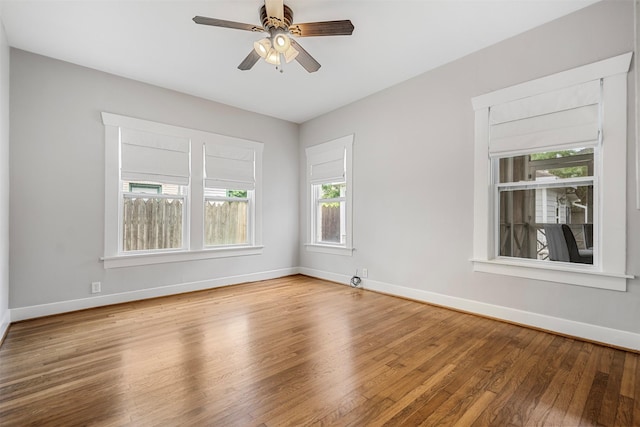 empty room featuring baseboards, ceiling fan, and wood finished floors