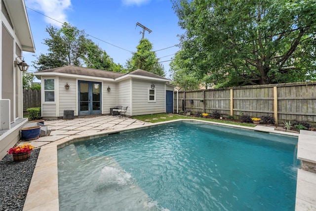 view of swimming pool featuring a fenced in pool, a fenced backyard, french doors, and a patio