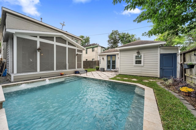 view of swimming pool with a sunroom, a fenced backyard, a patio area, and a fenced in pool