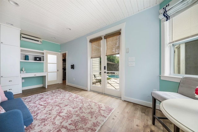 interior space featuring baseboards, wood ceiling, a wall mounted AC, and wood finished floors