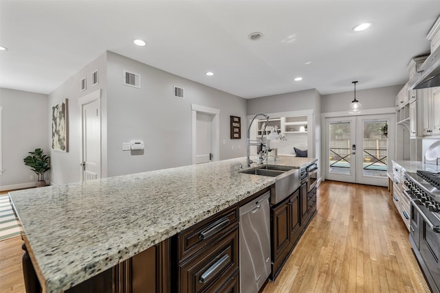kitchen featuring visible vents, french doors, a sink, light wood-style flooring, and stainless steel appliances
