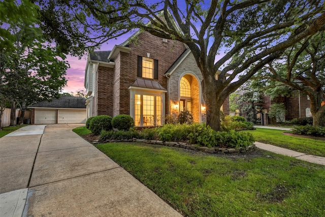 traditional home with a garage, a front yard, and brick siding