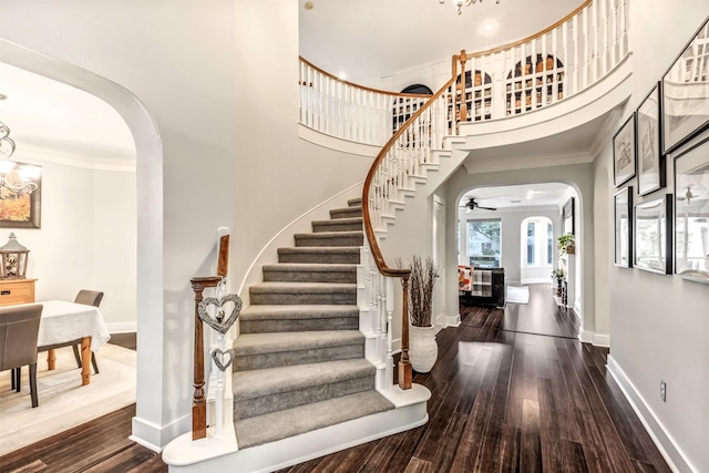 foyer entrance featuring arched walkways, stairway, and hardwood / wood-style floors
