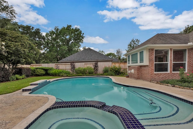 view of pool with a pool with connected hot tub and fence