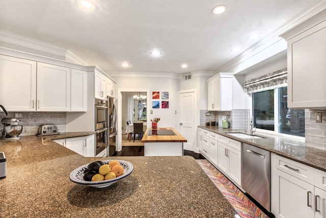 kitchen with visible vents, white cabinets, a chandelier, and stainless steel appliances