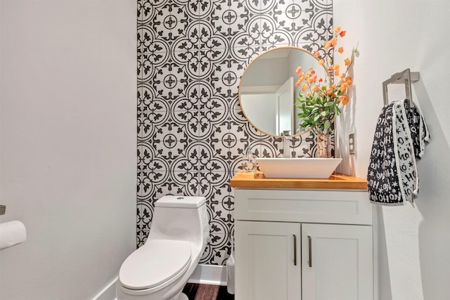 half bathroom with vanity and toilet