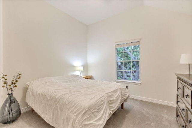 bedroom with baseboards, light carpet, and vaulted ceiling
