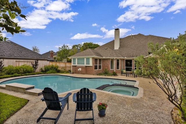 view of swimming pool with a patio, a pool with connected hot tub, and a fenced backyard