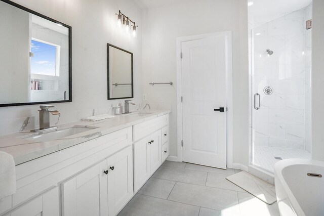 full bathroom featuring baseboards, a sink, double vanity, and a stall shower