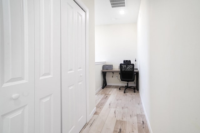 office with light wood-type flooring, baseboards, and visible vents