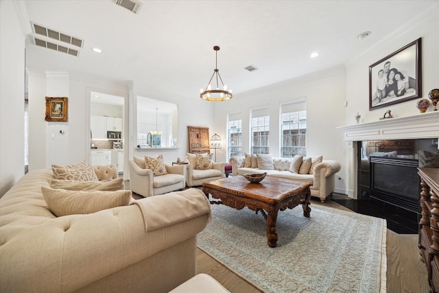 2842 Briarhurst Park, Houston, TX 77057 - living area featuring an inviting chandelier, ornamental molding, visible vents, and a fireplace