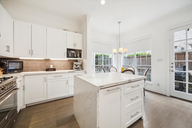2842 Briarhurst Park, Houston, TX 77057 - kitchen with decorative backsplash, stainless steel range with gas stovetop, a chandelier, and ornamental molding