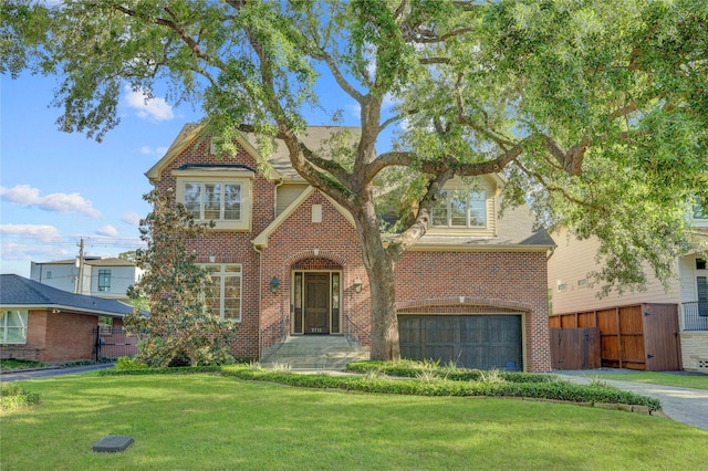 view of front facade with fence, a front lawn, an attached garage, driveway, and brick siding