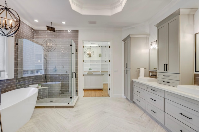 bathroom featuring recessed lighting, a shower stall, double vanity, crown molding, and a soaking tub