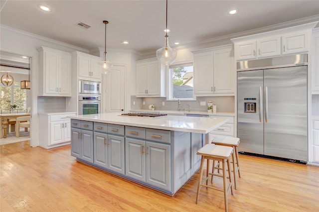 kitchen with white cabinetry, a center island, built in appliances, and gray cabinets