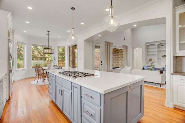 kitchen featuring a kitchen island, light wood finished floors, gray cabinets, and stainless steel appliances