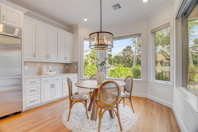 dining space featuring an inviting chandelier, a wealth of natural light, and visible vents