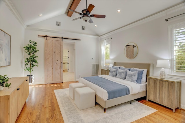 bedroom with a barn door, light wood-style floors, and visible vents