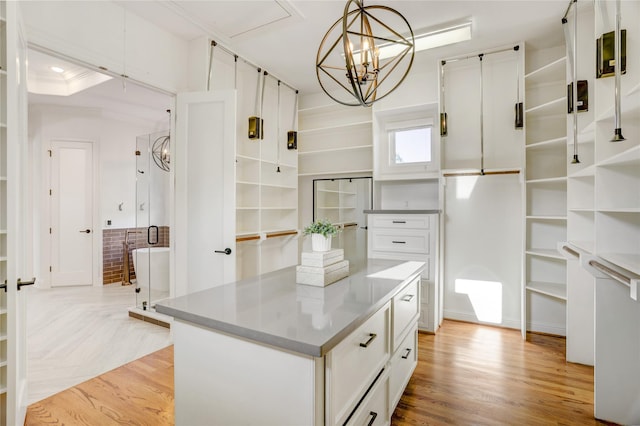 spacious closet featuring a notable chandelier and light wood-style flooring