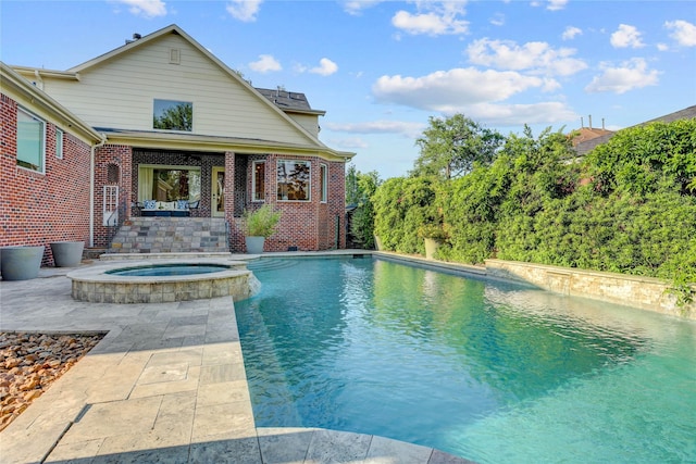 view of pool featuring a pool with connected hot tub and a patio area