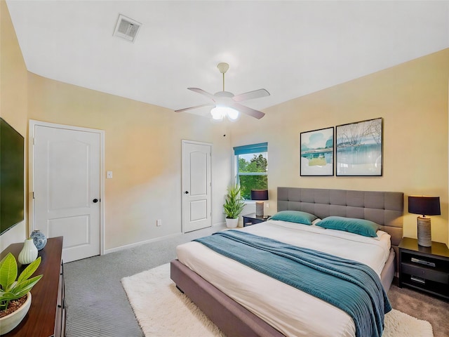 carpeted bedroom featuring baseboards, a ceiling fan, and visible vents