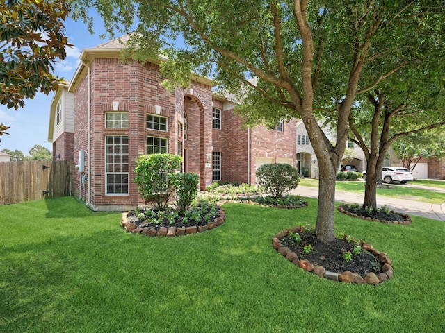 view of front of home featuring a garage, fence, a front yard, brick siding, and concrete driveway