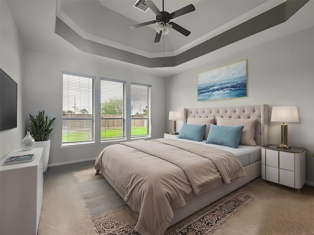 carpeted bedroom featuring crown molding, a raised ceiling, a ceiling fan, baseboards, and visible vents