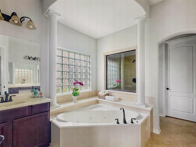 bathroom featuring a tub with jets, decorative columns, tile patterned floors, and vanity