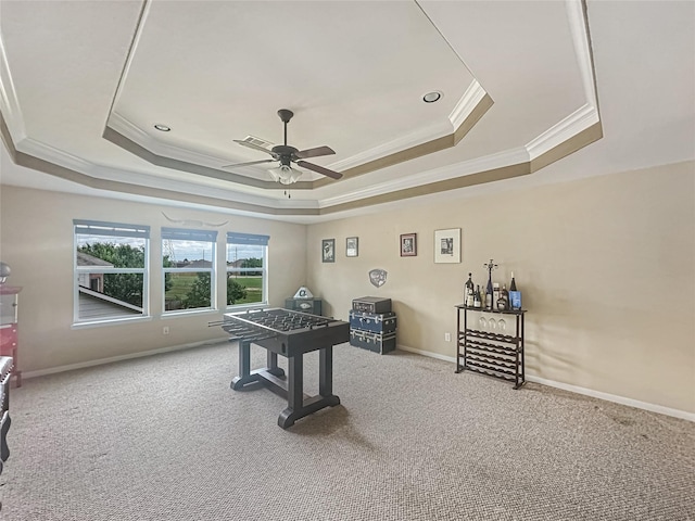 playroom featuring ornamental molding, a tray ceiling, and carpet flooring
