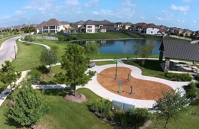 view of home's community with a residential view, a water view, and a yard